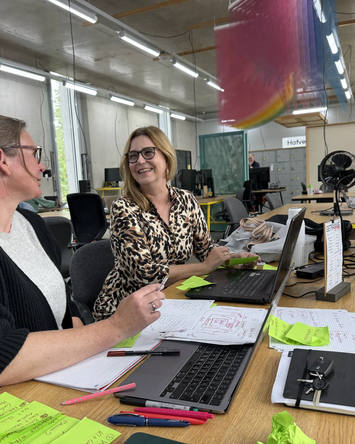 Michaela Werner im Gespräch am Coworking-Tisch im Hafven, Notizen und Post-its auf dem Tisch