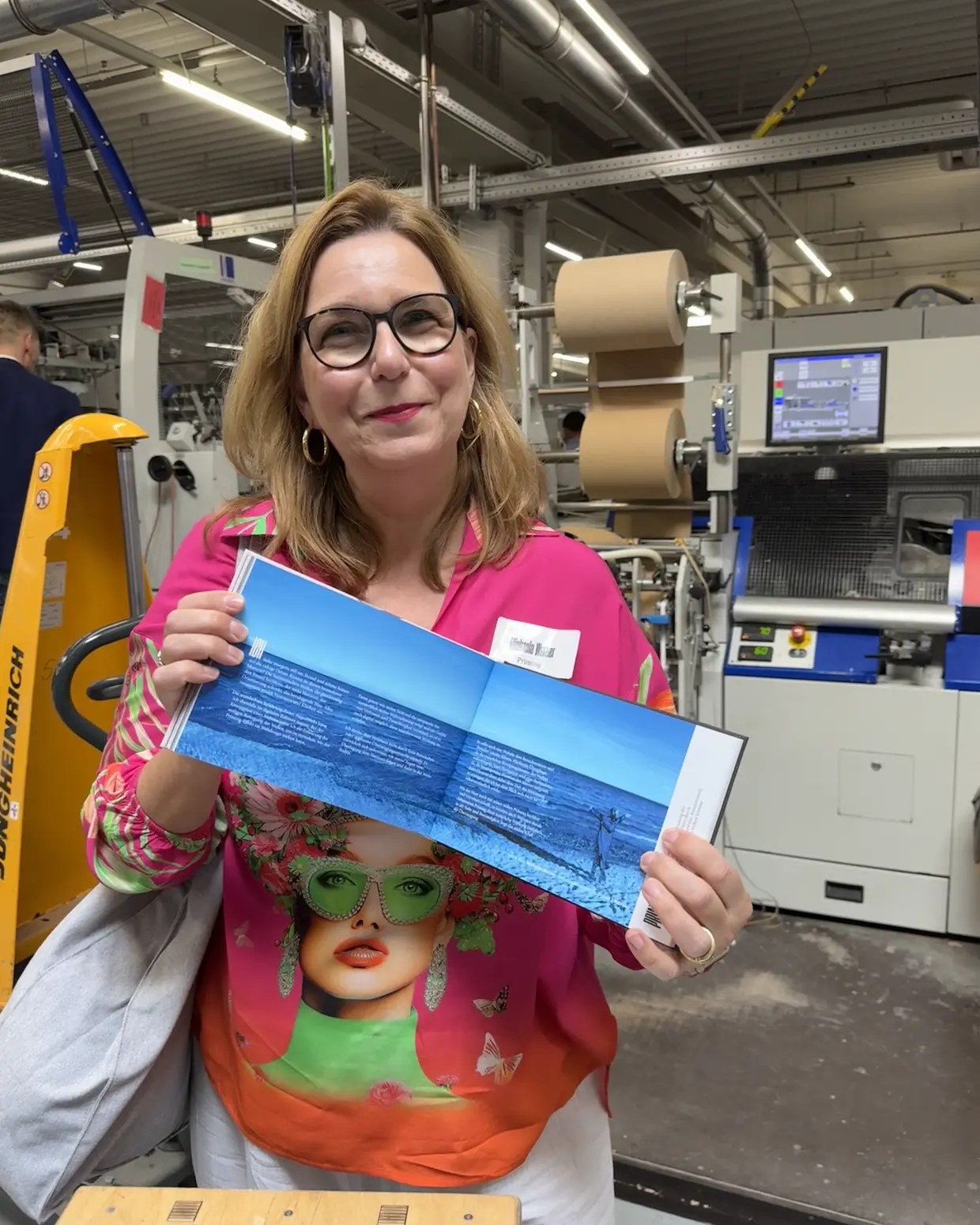 Michaela Werner in der Druckerei mit der gedruckten Broschüre in den Händen